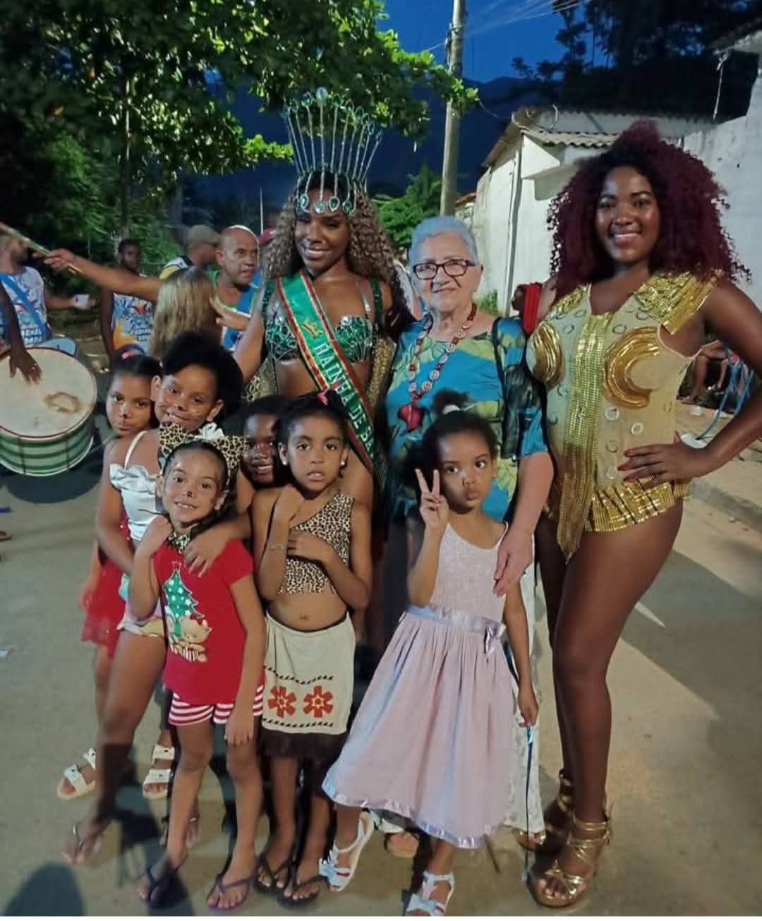Rainha de bateria com moradoras e crianças da comunidade